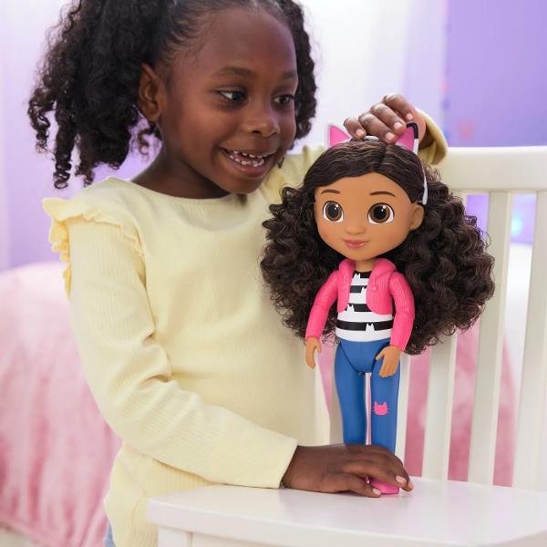 Descopera aventuri magice alaturi de Gabby Girl din Gabbys Dollhouse Aceasta papusa de 33 cm este imbracata in adidasii sai clasici blugi cu un petic adorabil de pisicuta un outfit stilizat si bentita cu urechi de pisica Bentita este detasabila si include parul moale si cret pe care il poti aranja cum doresti Papusa este perfecta pentru jocuri interactive avand brate si picioare pozabile Este cadoul ideal pentru copii si fanii serialului Alatura-te noii tale prietene Gabby pentru 