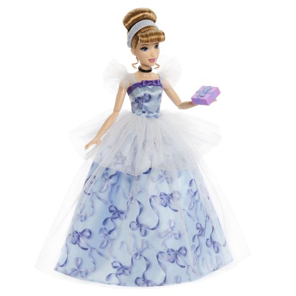 Sarbatoreste o zi de nastere speciala cu aceasta frumoasa papusa Disney Printesa Cenusareasa inspirata de indragitul personaj animat din filmul Disney Papusa Cenusareasa 30 cm este imbracata in stil festiv purtand o rochie eleganta cu corsaj cu panglici si maneci din tul cu volane Rochia ei este imprimata cu panglici de cadou albastre fanteziste si acoperita cu tul deschis la culoare Un peplum din tul cu buline completeaza aspectul fermecat al petrecerii Coafura eleganta a papusii 