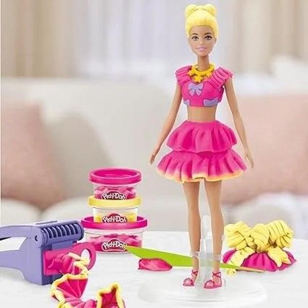 Creeaza stiluri super dragute cu setul Volanase si Fundite Este usor si distractiv sa creezi haine pentru papusa Barbie Play-Doh cu acest kit de arte si mestesuguri Pur si simplu aseaza papusa pe suport foloseste foaia cu modele Play-Doh si decupatoarele pentru a croi rochite Barbie si imbrac-o in cele mai creative moduri imaginabile Ofera-i diferite coafuri Play-Doh cu ajutorul matritei de par sau copiii isi pot face propriile coafuri manual Adauga accesorii pentru papusa Barbie cum ar fi 
