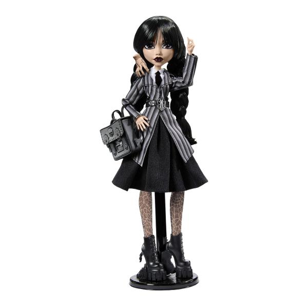 Papusa Wednesday este un must-have pentru fanii seriei Monster High imbinand stilul intunecat cu detalii elaborate care transforma aceasta papusa intr-o piesa de colectie deosebita Papusa poarta uniforma Academiei Nevermore completata de detalii unice precum cravata cureaua si ciorapii cu imprimeu de paianjen care subliniaza estetica ei sumbra si eleganta Cizmele papusii sunt decorate cu elemente inspirate din universul Wednesday Pe un toc este sculptat violoncelul ei iar pe celalalt 