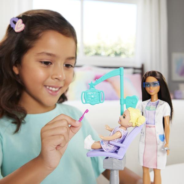 Descopera setul de joaca Barbie Bruneta Stomatolog ideal pentru copiii care vor sa exploreze lumea stomatologiei prin joaca Acest set ofera oportunitatea de a descoperi importanta ingrijirii dentare si de a dezvolta imaginatia prin scenarii realiste Setul include o papusa Barbie bruneta imbracata in uniforma de dentist cu halat alb si ochelari de protectie pregatita sa ofere cele mai bune tratamente dentare Scaunul de consultatie este special conceput pentru micii pacienti iar setul 