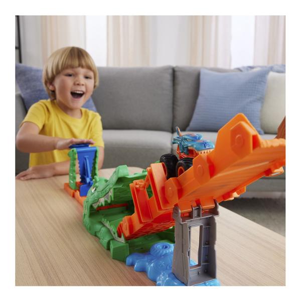 Pregateste-te pentru actiune la scara mare cu setul Hot Wheels Monster Trucks Provocarea Crocodilului cu masinuta inclusa o provocare spectaculoasa plina de viteza si impact Arena este dominata de un crocodil urias cu falci deschise gata sa prinda camionul Monster Truck in timpul cursei Copilul lanseaza vehiculul pe rampa tintind direct spre tinta pentru a dobori obstacolul si a invinge crocodilul Setul include un Monster Truck Mega Wrex realizat in stil robust cu roti supradimensionate 