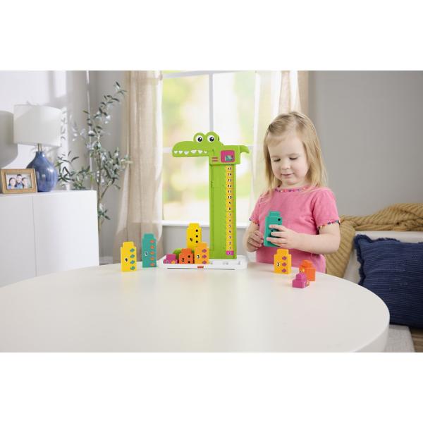 Jucaria educativa Fisher-Price Stivuibila Alligator ii ajuta pe copii sa invete concepte matematice de baza prin joc si interactiune Designul colorat in forma de crocodil transforma invatarea numerelor si a adunarilor simple intr-o activitate distractiva Setul include blocuri numerotate si un mecanism glisant care permite copiilor sa combine numerele si sa descopere rezultatul pe scala de calcul Prin manipularea pieilor si rezolvarea provocarilor simple copiii isi dezvolta gandirea logica 