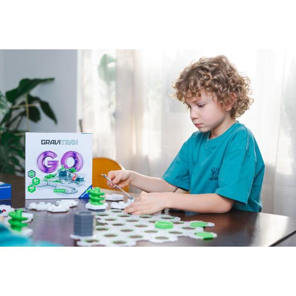 Descopera lumea fascinanta GraviTrax cu setul de constructie Rotativ conceput pentru realizarea unor trasee spectaculoase pentru bile Cele 40 de piese permit construirea unui circuit dinamic prevazut cu elemente rotative care schimba directia si adauga mai multa actiune fiecarei curse Copiii pot experimenta cu gravitatia viteza si miscarea dezvoltandu-si gandirea logica creativitatea si abilitatile de rezolvare a problemelor Setul reprezinta o introducere potrivita in universul GraviTrax 