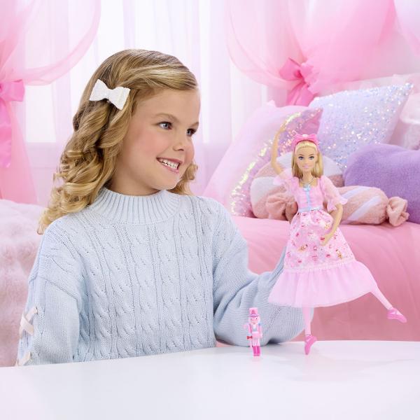 Papusa Clara din colectia Barbie Spargatorul de Nuci este inspirata de povestea clasica si de universul Barbie in the Nutcracker Clara poarta o rochie eleganta de balerina in nuante de roz cu detalii delicate maneci transparente si accesorii asortate completate de pantofi de balet Papusa este prevazuta cu functie de miscare a picioarelor pentru a recrea pozitii si miscari de balet iar setul include si un accesoriu tematic Spargator de Nuci Este potrivita pentru joaca de rol povesti 