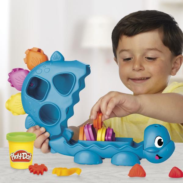 Acest set de joaca creativ ii ajuta pe cei mici sa invete formele si culorile intr-un mod distractiv Dinozaurul prietenos are spatii speciale pentru diferite forme iar copiii pot folosi plastilina colorata pentru a le modela si potrivi Setul include 6 recipiente de Play Doh in culori variate si accesorii pentru joaca interactiva Potrivit pentru copiii de la 2 ani in sus acest set stimuleaza imaginatia abilitatile motorii fine si invatarea prin joaca transformand fiecare activitate intr-o 