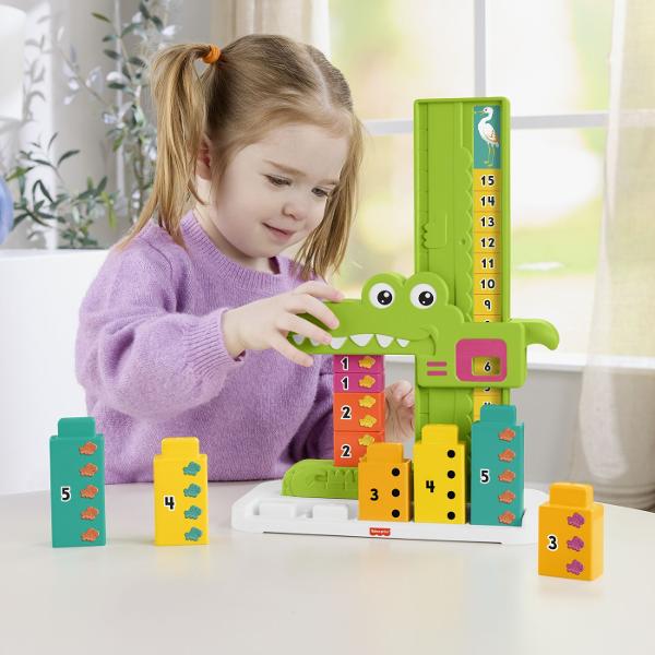 Jucaria educativa Fisher-Price Stivuibila Alligator ii ajuta pe copii sa invete concepte matematice de baza prin joc si interactiune Designul colorat in forma de crocodil transforma invatarea numerelor si a adunarilor simple intr-o activitate distractiva Setul include blocuri numerotate si un mecanism glisant care permite copiilor sa combine numerele si sa descopere rezultatul pe scala de calcul Prin manipularea pieilor si rezolvarea provocarilor simple copiii isi dezvolta gandirea logica 