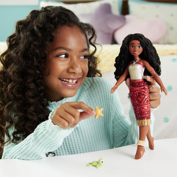 Papusa inspirata din universul Disney Vaiana 2 aduce aventura oceanului in joaca copiilor Personajul este imbracat in costumul sau traditional cu detalii inspirate din cultura insulelor tropicale si sunt par lung ondulat Setul include o figurina mica de broasca testoasa si un accesoriu in forma de stea de mare pentru a recrea scenele din poveste Papusa poate pluti in apa si are efect special de schimbare a culorii atunci cand este scufundata in apa oferind o experienta de joaca interactiva 