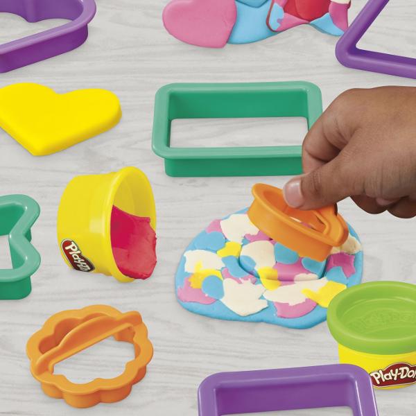 Setul Play-Doh Forme este ideal pentru primele activitati creative cu plastilina oferind copiilor posibilitatea de a modela presa si decupa diferite forme intr-un mod distractiv Setul include forme geometrice si accesorii de modelaj precum si plastilina Play-Doh in 6 culori cu o cantitate totala de 170 g Joaca ajuta la dezvoltarea creativitatii coordonarii mana-ochi si motricitatii fine incurajand copiii sa combine culorile si sa creeze propriile modele Recomandat copiilor cu varsta de 