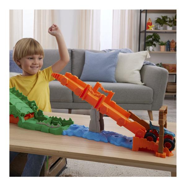 Pregateste-te pentru actiune la scara mare cu setul Hot Wheels Monster Trucks Provocarea Crocodilului cu masinuta inclusa o provocare spectaculoasa plina de viteza si impact Arena este dominata de un crocodil urias cu falci deschise gata sa prinda camionul Monster Truck in timpul cursei Copilul lanseaza vehiculul pe rampa tintind direct spre tinta pentru a dobori obstacolul si a invinge crocodilul Setul include un Monster Truck Mega Wrex realizat in stil robust cu roti supradimensionate 