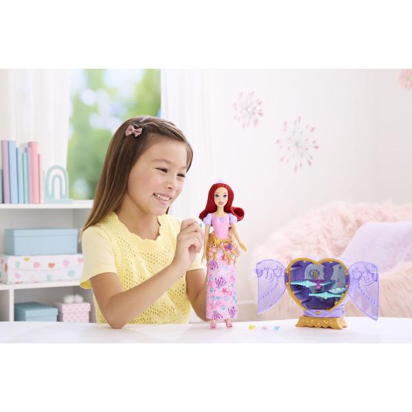 Setul Disney Princess Jewel Reveal aduce magia lumii Disney intr-o experienta plina de surprize si descoperiri Ambalat intr-o cutie eleganta in forma de inima stralucitoare setul ascunde in interior o papusa Ariel inspirata din universul Printeselor Disney si mai multe accesorii surpriza Copiii pot deschide compartimentele pentru a descoperi treptat elementele incluse precum accesorii de moda si detalii inspirate din poveste Designul sclipitor si mecanismul de deschidere transforma fiecare 