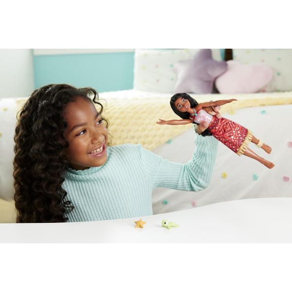 Papusa inspirata din universul Disney Vaiana 2 aduce aventura oceanului in joaca copiilor Personajul este imbracat in costumul sau traditional cu detalii inspirate din cultura insulelor tropicale si sunt par lung ondulat Setul include o figurina mica de broasca testoasa si un accesoriu in forma de stea de mare pentru a recrea scenele din poveste Papusa poate pluti in apa si are efect special de schimbare a culorii atunci cand este scufundata in apa oferind o experienta de joaca interactiva 