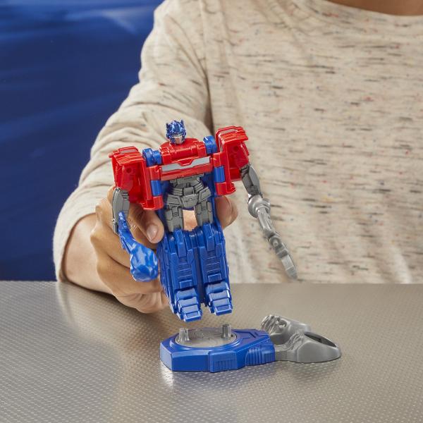 Experimentati originile epice ale robotilor legendari Transformers cu acest pachet de 2 figurine de actiune Transformers One Battling Robots care include figurina Optimus Prime si figura de actiune Megatron Asezati figurinele de actiune pe baza de lupta si glisati fantele pentru degete pentru miscari interesante de actiune Arunca o figurina de la baza pentru a castiga Cifra Optimus Prime articulata de 45 inchi 115 cm se transforma intre jucarie robot si jucarie semi-camion in 3 pasi 