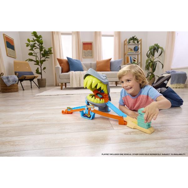 Setul de joaca Hot Wheels City Plaja Rechinului Chomp aduce actiune spectaculoasa pe pista unde masinutele trebuie sa scape din ghearele unui rechin urias Inspirat din universul Hot Wheels City acest circuit transforma plaja intr-o aventura plina de adrenalina si provocari pentru micii pasionati de curse Masinutele sunt lansate pe pista si trebuie sa treaca cu viteza prin zona periculoasa dominata de rechinul gigantic cu falci mobile Daca masina nu este suficient de rapida rechinul poate 