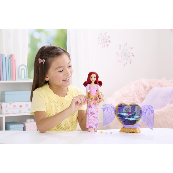 Setul Disney Princess Jewel Reveal aduce magia lumii Disney intr-o experienta plina de surprize si descoperiri Ambalat intr-o cutie eleganta in forma de inima stralucitoare setul ascunde in interior o papusa Ariel inspirata din universul Printeselor Disney si mai multe accesorii surpriza Copiii pot deschide compartimentele pentru a descoperi treptat elementele incluse precum accesorii de moda si detalii inspirate din poveste Designul sclipitor si mecanismul de deschidere transforma fiecare 
