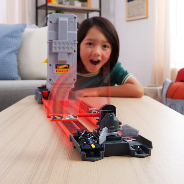 Circuitul de curse Hot Wheels Racing Grid Start Formula 1 2025 aduce emotia curselor de Formula 1 in universul Hot Wheels Setul permite copiilor sa organizeze curse rapide si competitii de reactie lansand simultan cele doua masinute incluse pe pista pentru a vedea cine ajunge primul la final Circuitul este inspirat de grila de start Formula 1 si include elemente tematice F1 precum turnul de start pista de curse si sistemul Hot Wheels Speed Snap conceput pentru o asamblare rapida si usoara 