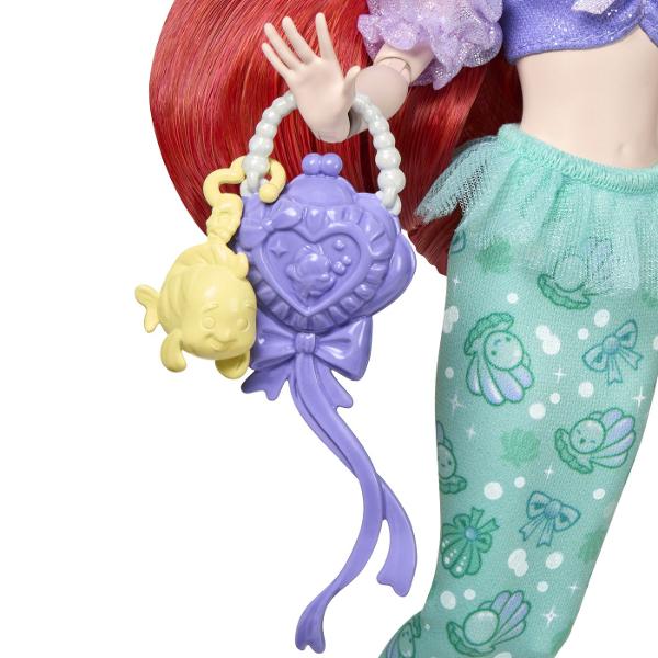 Papusa Ariel din colectia Disney Princess este inspirata de indragitul personaj din povestea Mica Sirena Papusa are aproximativ 23 cm inaltime si poarta o tinuta in nuante de mov si turcoaz cu detalii inspirate de lumea subacvatica Parul lung roscat si accesoriile tematice completeaza aspectul specific personajului Ariel Papusa este potrivita pentru recrearea scenelor preferate din povestea Disney si pentru inventarea unor noi aventuri pline de imaginatie Inaltime papusa aproximativ 23 cm 