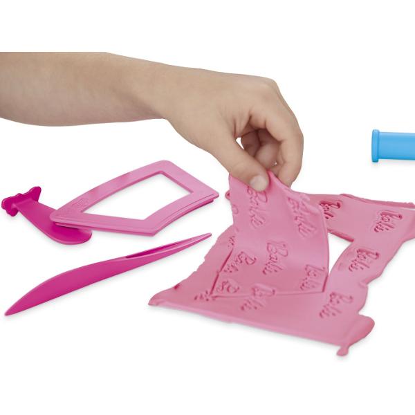 Creeaza stiluri super dragute cu setul Inimioare si Par Este usor si distractiv sa creezi haine pentru papusa Barbie Play-Doh cu acest kit de arte si mesteruguri Pur si simplu aseaza papusa pe suport foloseste foaia cu modelul Play-Doh si decupatoarele pentru a croi rochite Barbie si imbrac-o in cele mai creative moduri imaginabile Ofera-i 2 coafuri Play-Doh diferite cu matritele pentru par scurt si lung sau copii isi pot face propriile coafuri manual Adauga accesorii pentru papusa Barbie 