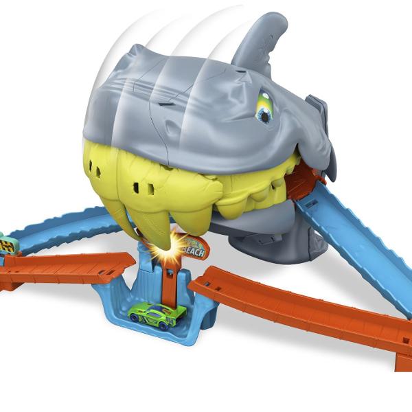 Setul de joaca Hot Wheels City Plaja Rechinului Chomp aduce actiune spectaculoasa pe pista unde masinutele trebuie sa scape din ghearele unui rechin urias Inspirat din universul Hot Wheels City acest circuit transforma plaja intr-o aventura plina de adrenalina si provocari pentru micii pasionati de curse Masinutele sunt lansate pe pista si trebuie sa treaca cu viteza prin zona periculoasa dominata de rechinul gigantic cu falci mobile Daca masina nu este suficient de rapida rechinul poate 