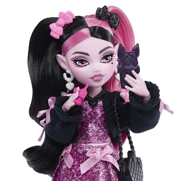 Intra in atmosfera gotica si plina de stil din universul Monster High cu papusa Draculaura un personaj emblematic cu un look adorabil si indraznet Draculaura impresioneaza prin parul lung in doua nuante contrastante si tinuta stralucitoare in tonuri de roz si negru completata de accesorii statement si detalii inspirate din tematica vampirica Setul include diverse accesorii pentru joaca precum are eleganta telefon gustare bautura tematica ochelari si un animal de companie cu design 